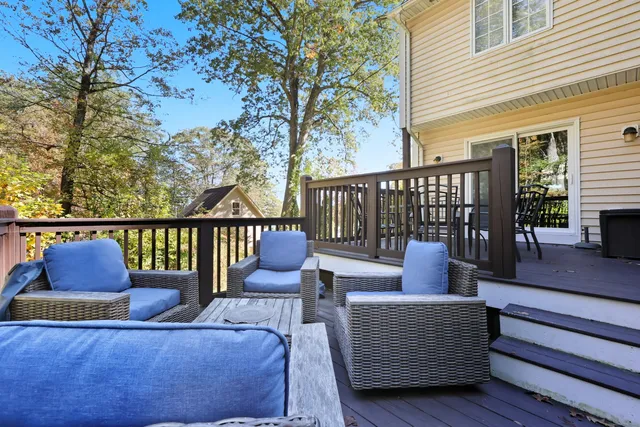 a outdoor sitting area with chairs and wooden floor