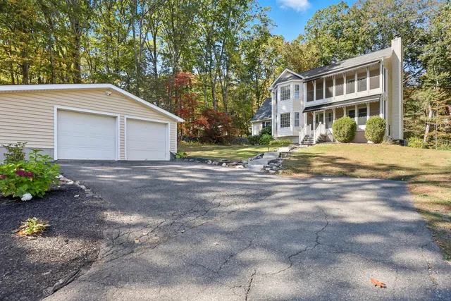 a front view of house with yard and trees around