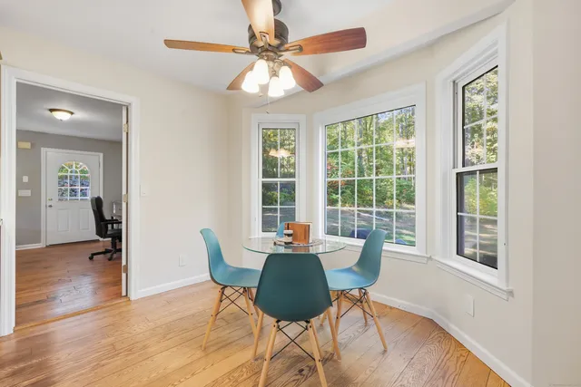a dining room with furniture a chandelier and wooden floor
