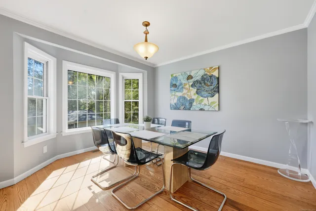 a view of a dining room with furniture a chandelier and wooden floor