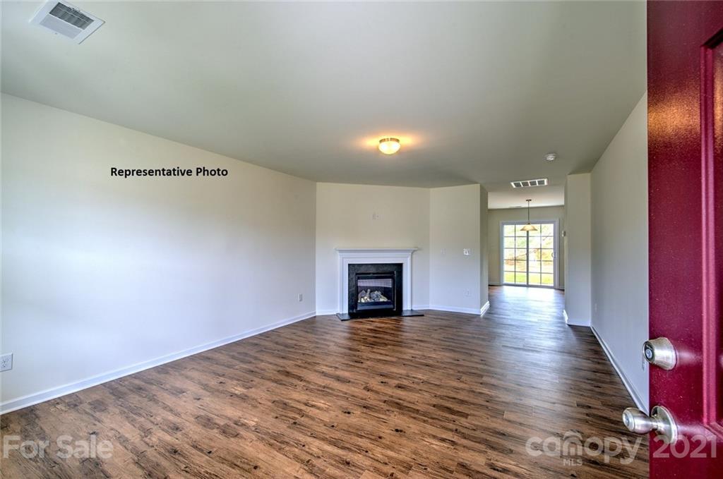 7112 Finnigan Road Charlotte, NC 28215 - Photo 2 of 33 an empty room with wooden floor fireplace and windows