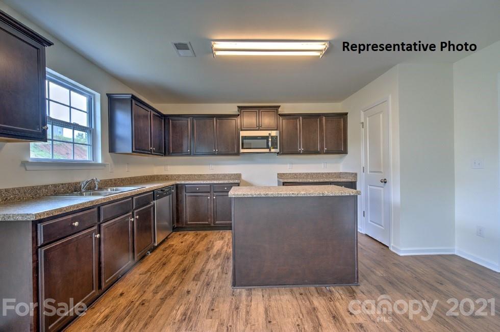 7112 Finnigan Road Charlotte, NC 28215 - Photo 12 of 33 a kitchen with stainless steel appliances granite countertop wooden cabinets a stove top oven a sink and dishwasher