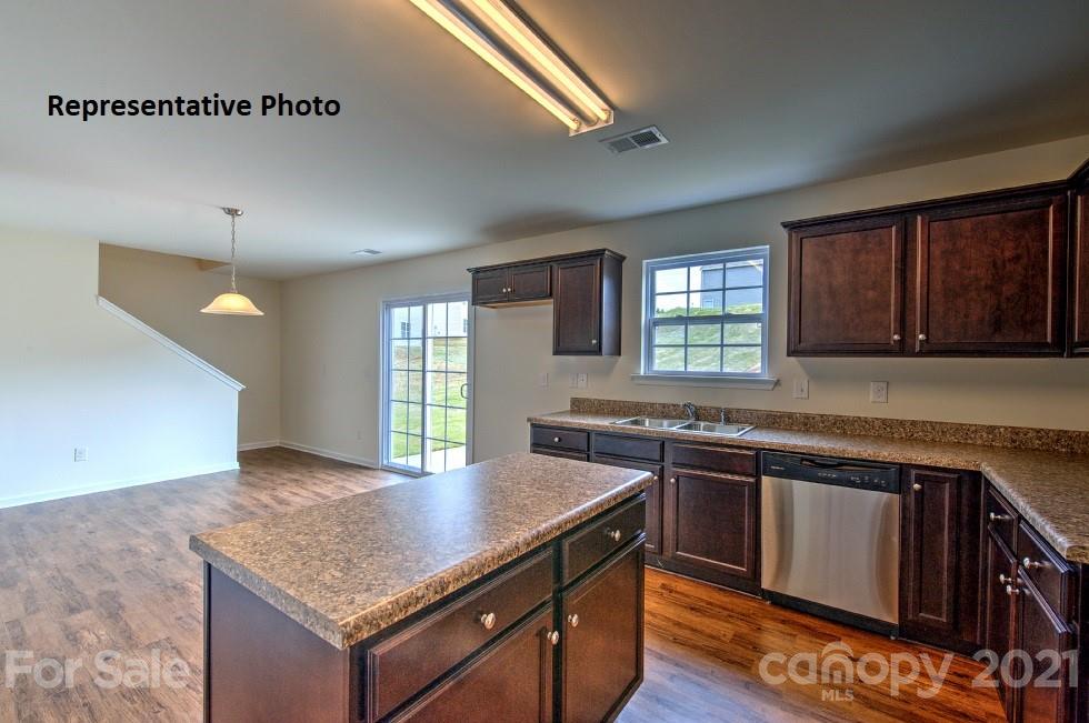 7112 Finnigan Road Charlotte, NC 28215 - Photo 20 of 33 a kitchen with stainless steel appliances granite countertop a stove a sink dishwasher and microwave with wooden floor