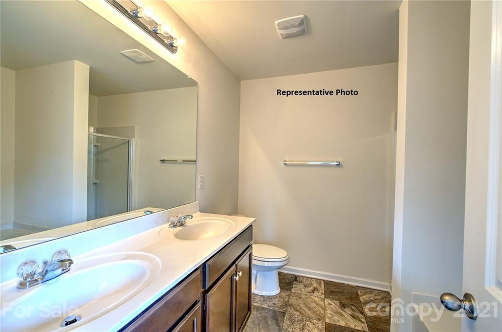 7112 Finnigan Road Charlotte, NC 28215 - Photo 28 of 33 a bathroom with a granite countertop sink and a mirror