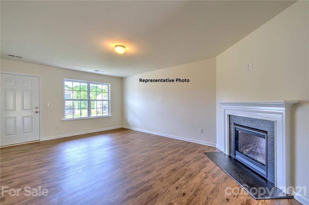 7112 Finnigan Road Charlotte, NC 28215 - Photo 6 of 33 an empty room with wooden floor fire place and windows