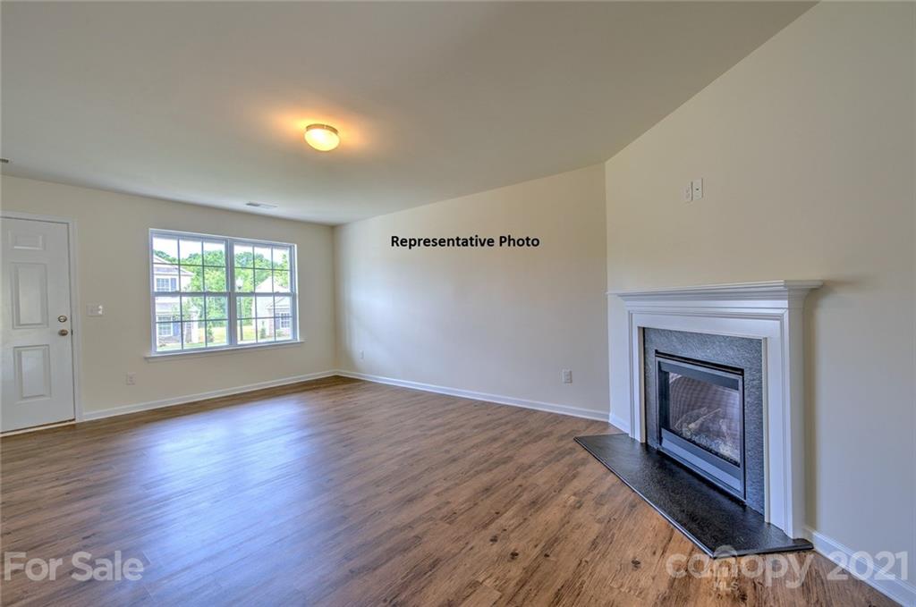 7112 Finnigan Road Charlotte, NC 28215 - Photo 7 of 33 an empty room with wooden floor fireplace and windows