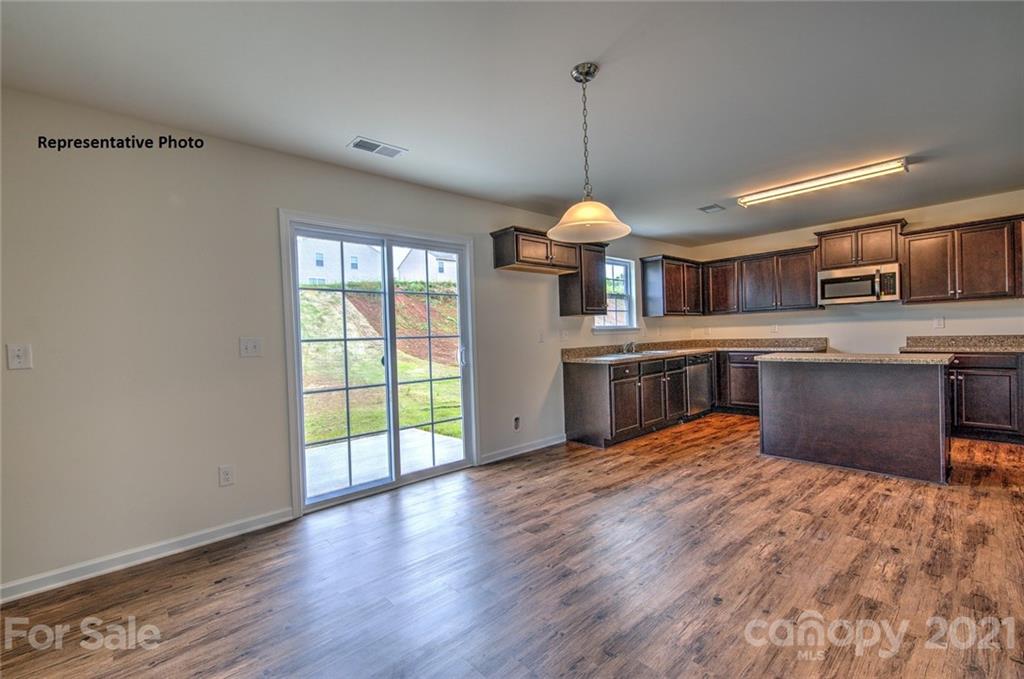 7112 Finnigan Road Charlotte, NC 28215 - Photo 9 of 33 a view of a kitchen with a sink wooden floor a fireplace and windows