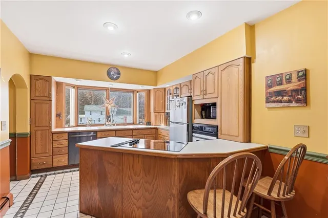 a living room with furniture stove and a large window