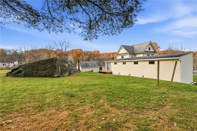 a view of a big house with a big yard and large trees
