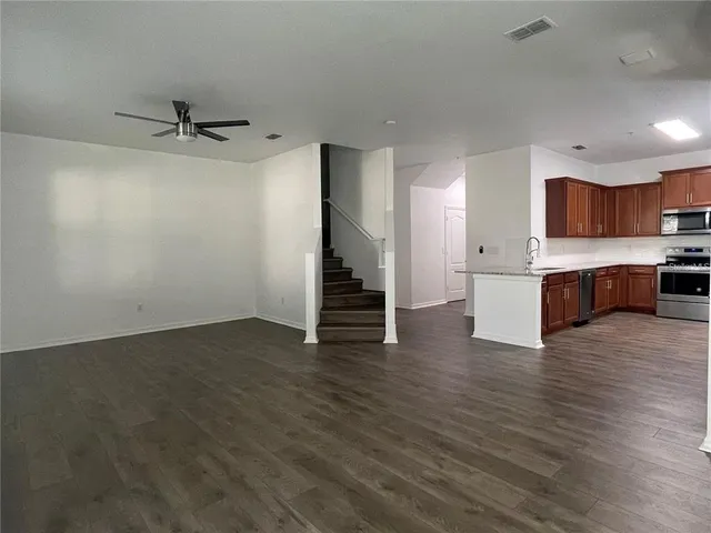 a view of kitchen with wooden floor and electronic appliances