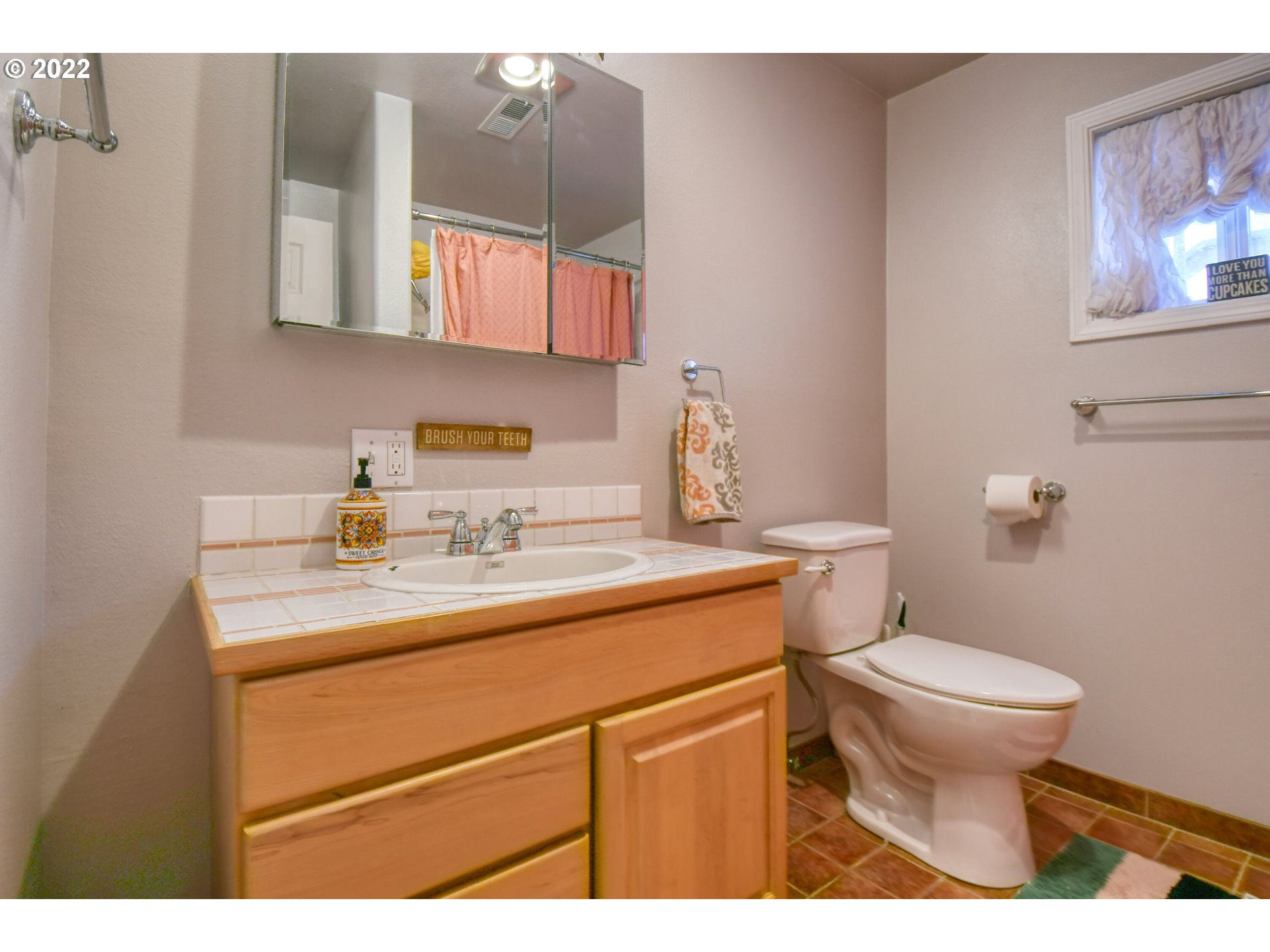2209 Southwest Ladow Avenue Pendleton, OR 97801 - Photo 19 of 24 a bathroom with a toilet a sink and mirror