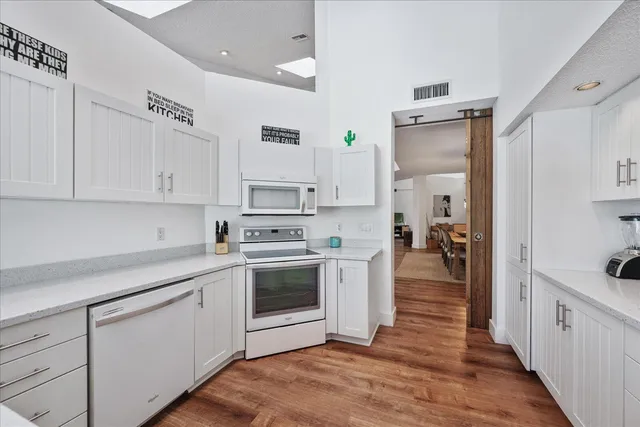 a kitchen with stainless steel appliances a white stove top oven cabinets and a refrigerator