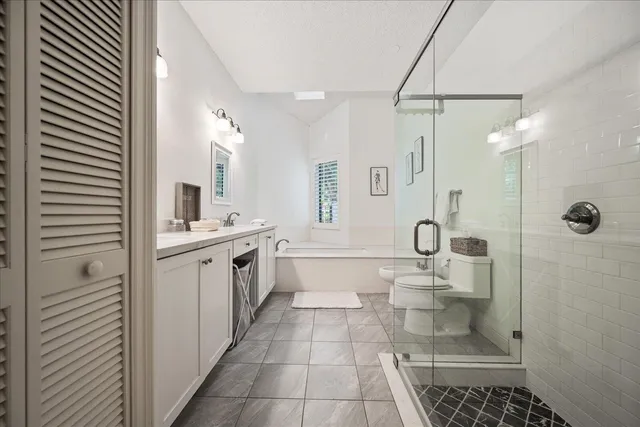 a bathroom with a granite countertop sink a toilet and a mirror