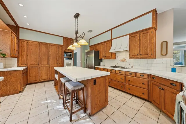 a kitchen with stainless steel appliances granite countertop a sink a stove and a wooden floors