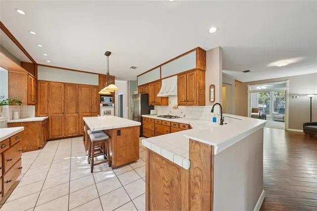 a kitchen with a sink a counter top space and stainless steel appliances
