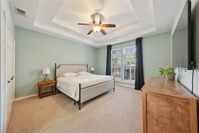 a spacious bedroom with a bed and a chandelier