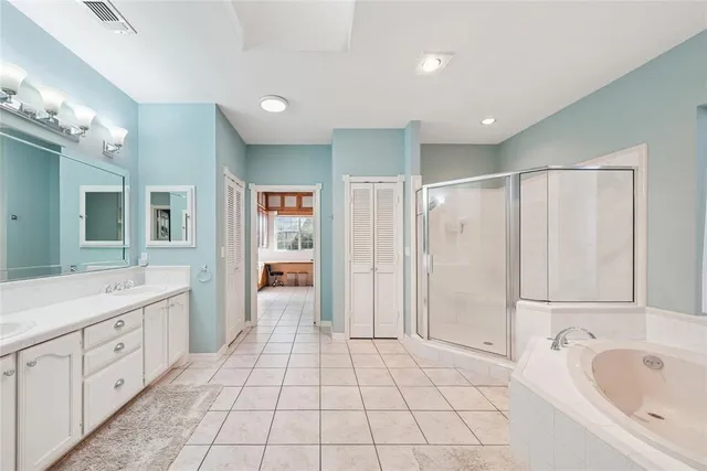 a large bathroom with a tub sink and mirror