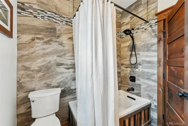 a bathroom with a toilet and shower
