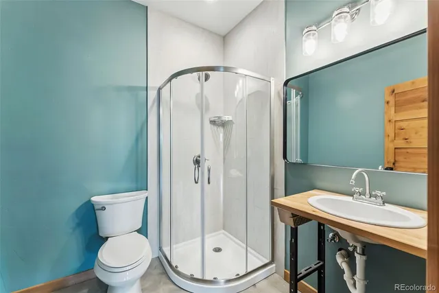 a bathroom with a granite countertop toilet a sink and a mirror