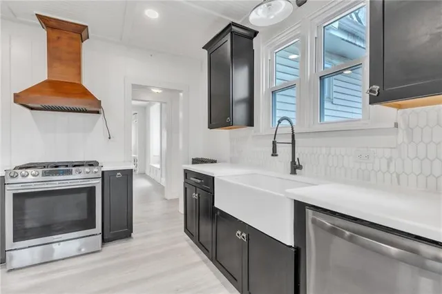 a kitchen with stainless steel appliances granite countertop a sink stove and refrigerator