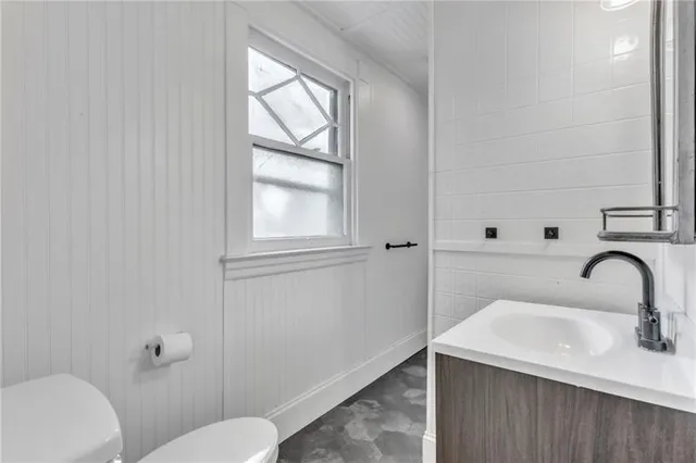 a bathroom with a sink mirror vanity and toilet