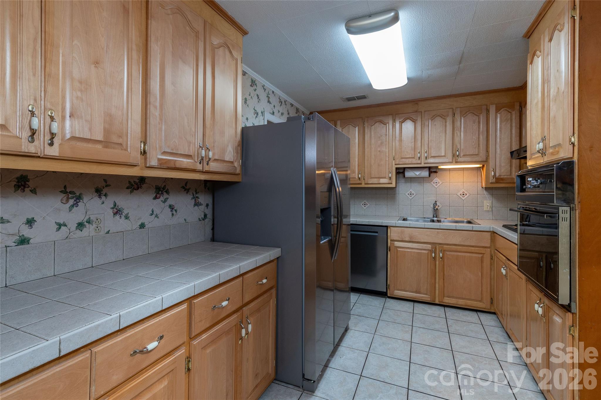 223 Cherry Street Sylva, NC 28779 - Photo 19 of 29 a kitchen with stainless steel appliances granite countertop a sink a stove a refrigerator and cabinets