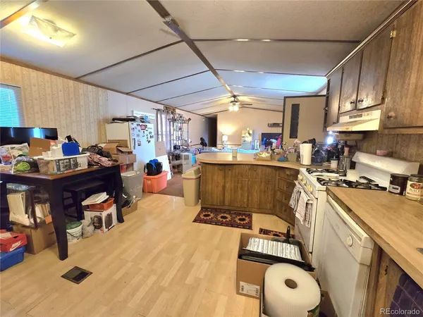 a view of a kitchen with kitchen island a large counter top space a sink a stove and a window
