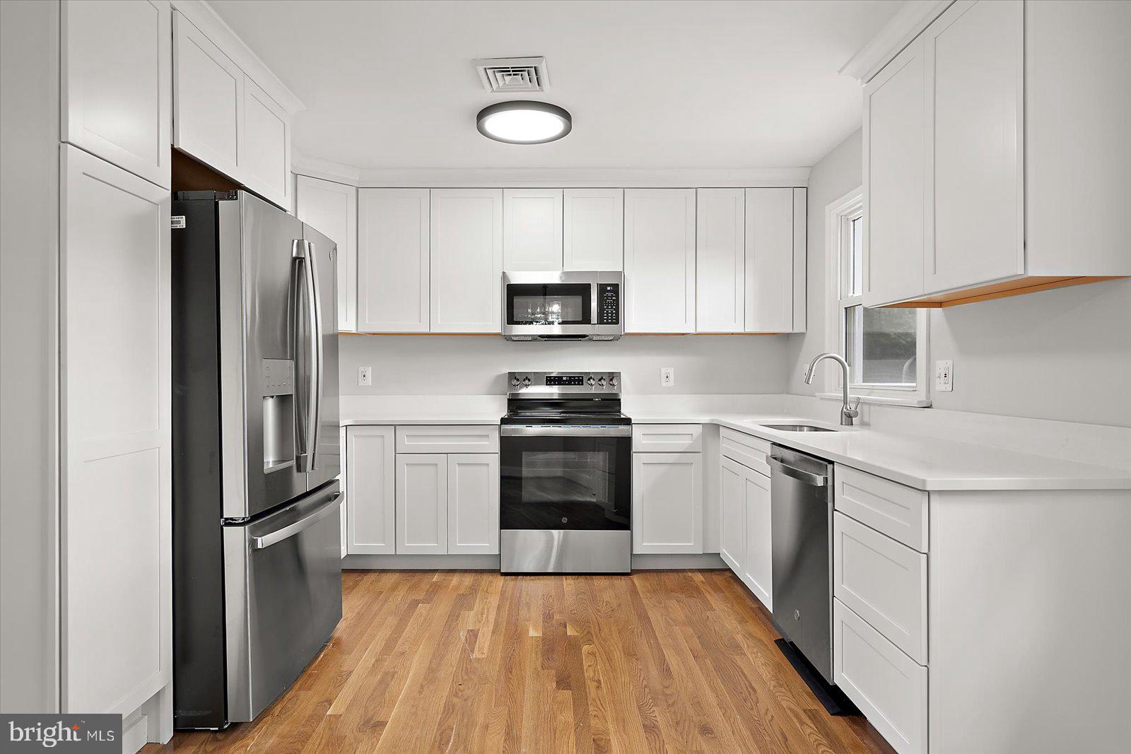31655 Morris Leonard Road Parsonsburg, MD 21849 - Photo 25 of 90 a kitchen with granite countertop a refrigerator stove and microwave