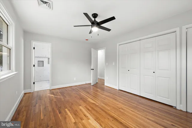 an empty room with wooden floor and window