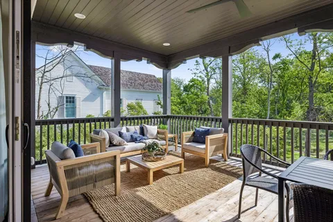 a balcony with wooden floor and outdoor seating
