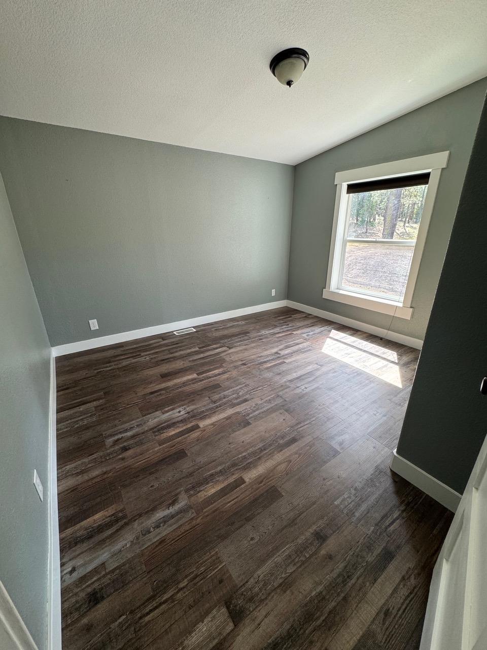 4678 Portola McLears Road Clio, CA 96106 - Photo 24 of 33 a view of an empty room with wooden floor and a window