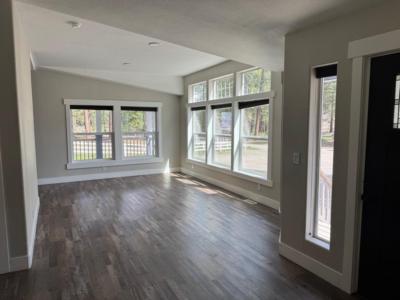 4678 Portola McLears Road Clio, CA 96106 - Photo 4 of 33 an empty room with wooden floor and windows