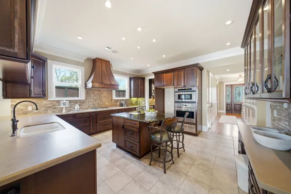 a kitchen with stainless steel appliances kitchen island granite countertop a sink and cabinets