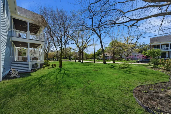 a view of a house with a big yard and large tree
