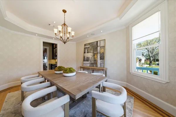 a view of a dining room with furniture a chandelier and wooden floor