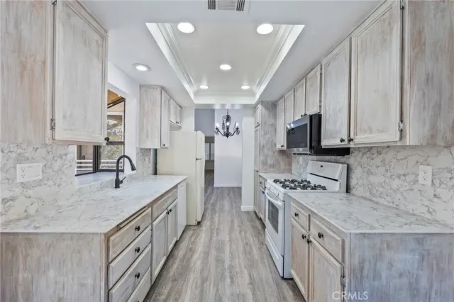 a kitchen with stainless steel appliances granite countertop a sink stove and refrigerator