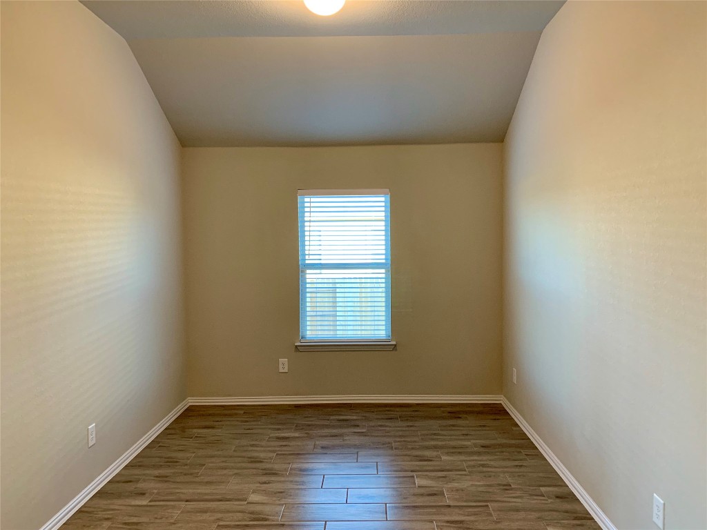 265 Falling Star Lane Georgetown, TX 78628 - Photo 2 of 22 a view of an empty room with wooden floor and a window