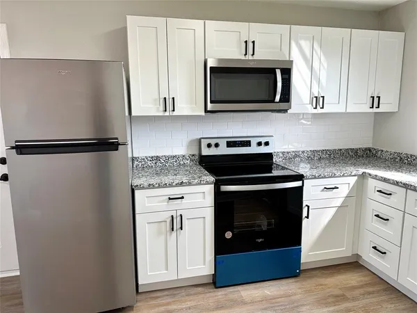 a kitchen with stainless steel appliances a stove microwave and refrigerator