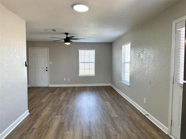 wooden floor in an empty room with a window
