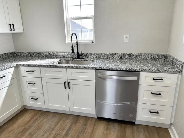 a kitchen with granite countertop a sink and a stove