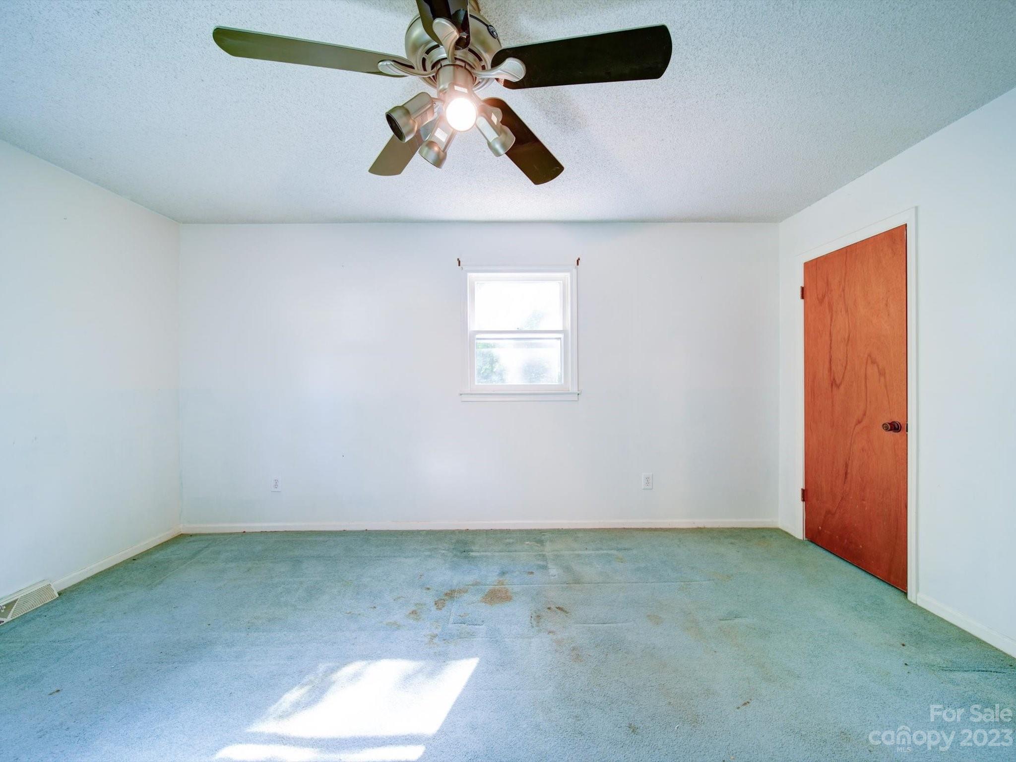 3938 Tater Ridge Road Concord, NC 28025 - Photo 9 of 23 an empty room with a chandelier fan and windows