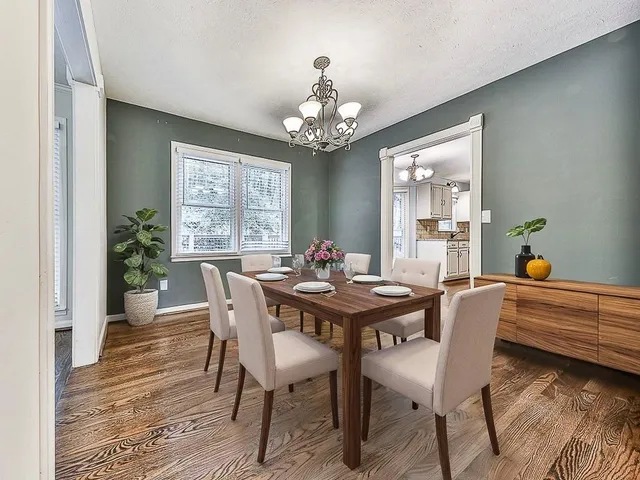 a view of a dining room with furniture a chandelier and wooden floor
