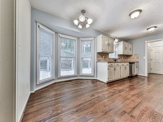a view of a kitchen with a stove wooden cabinets and a window