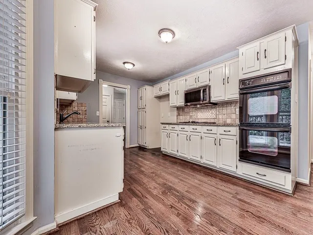 a kitchen with cabinets stainless steel appliances and a counter space