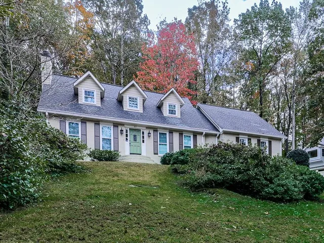 a front view of a house with a yard and trees