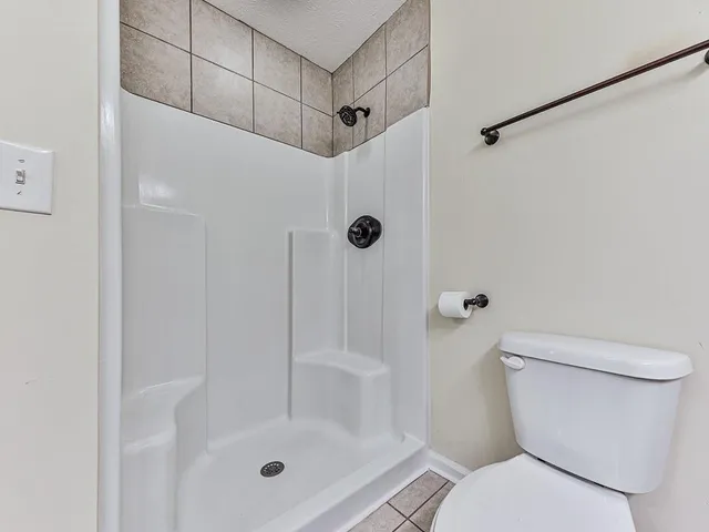 a bathroom with a shower a toilet and a shower