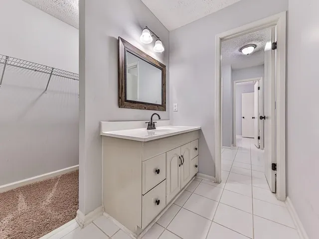 an empty room with chandelier fan and windows