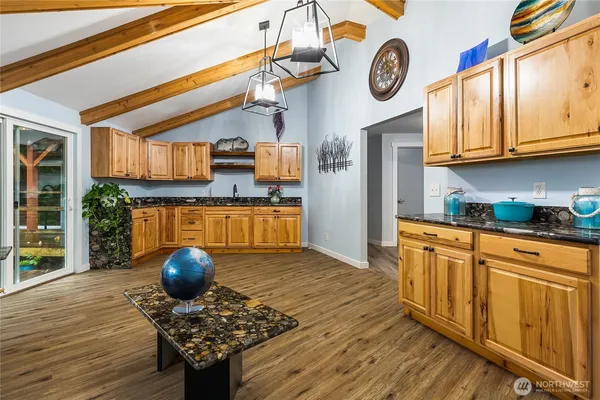 a kitchen with stainless steel appliances granite countertop a stove a sink dishwasher and cabinets with wooden floor