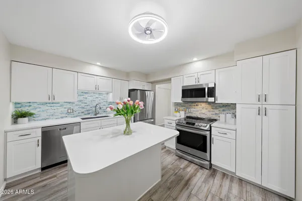 a kitchen with stainless steel appliances white cabinets and a sink
