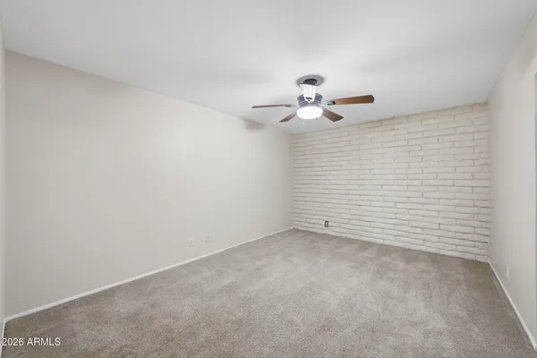 an empty room with a window and a ceiling fan